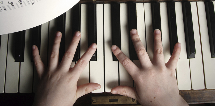 kinderhanden op piano